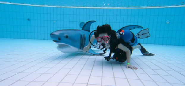 Kind ist mit einem Hai unter Wasser